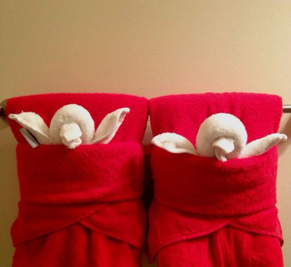 two red towels with white doves on them hanging from a towel rack in a bathroom