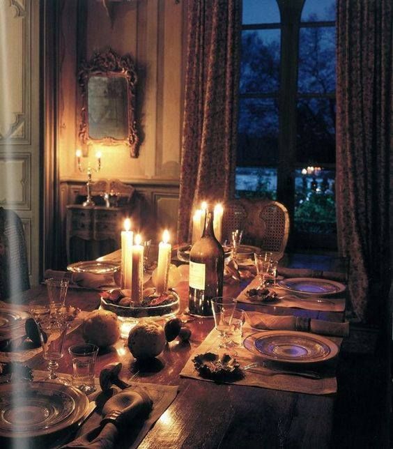 a dining room table is set with candles and plates