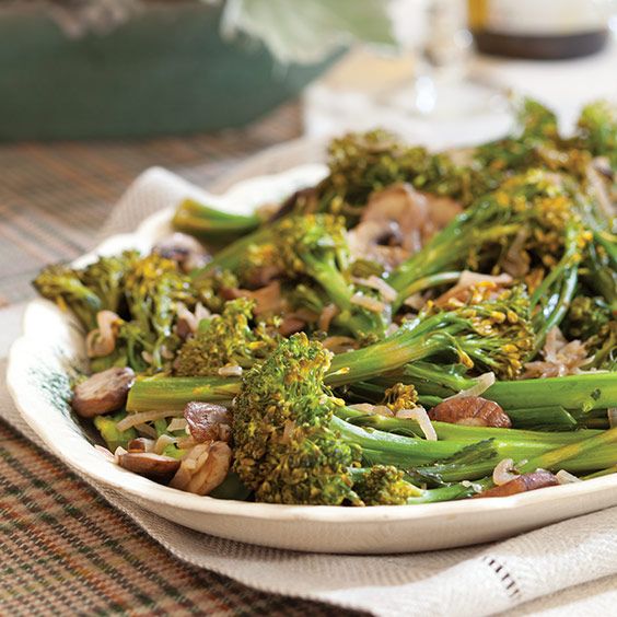 a white bowl filled with broccoli and mushrooms on top of a table cloth