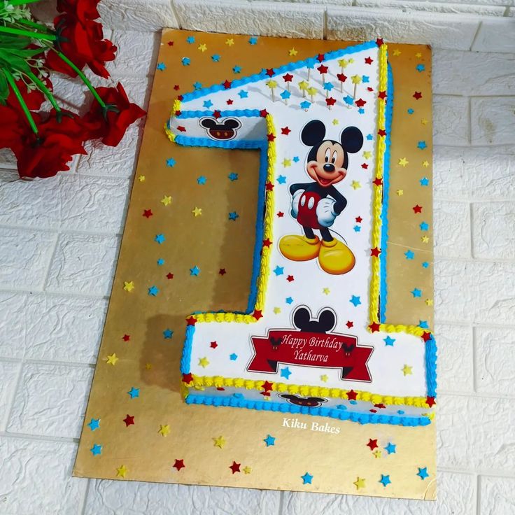 a birthday cake with the number one in mickey mouse's face on it and stars