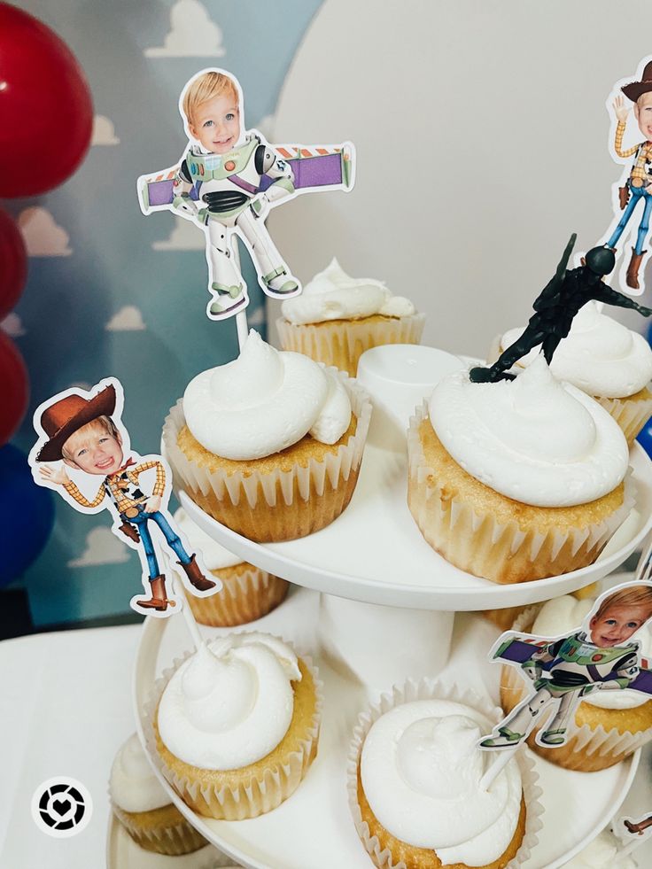 cupcakes on a cake stand with stickers in the shape of cartoon characters