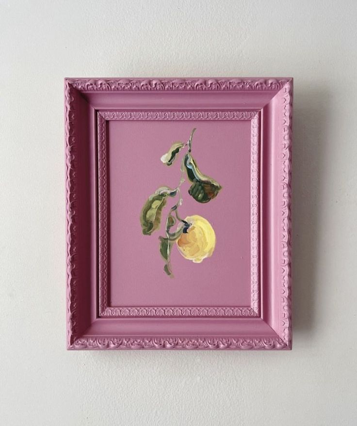 a pink frame hanging on the wall with two yellow flowers painted in watercolors