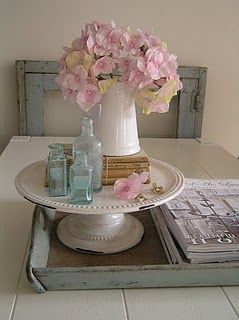 a tray with flowers and books on it