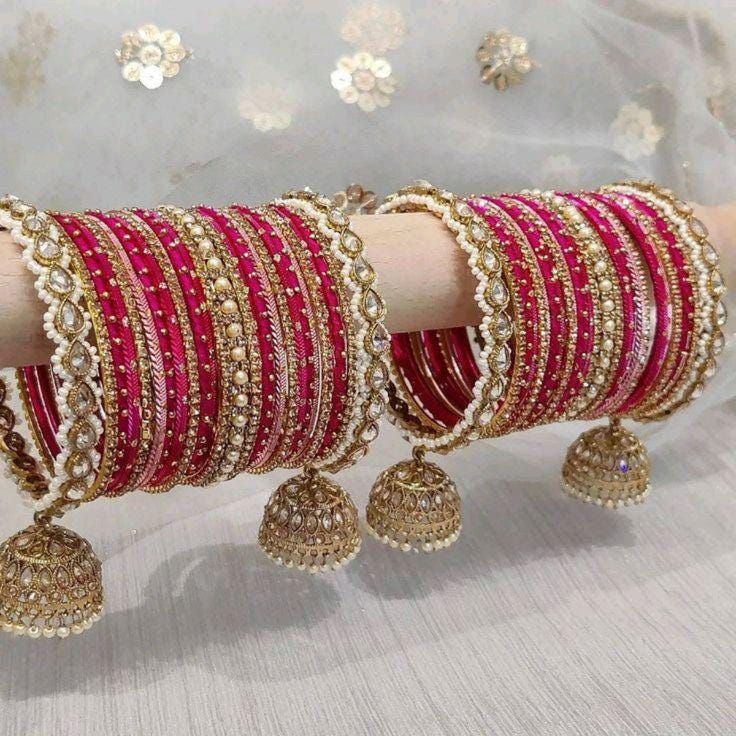 This set features a stunning pearl bracelet as the centerpiece, accented by elegant jhumki borders for both wrists (set of 2). 24 bangles on Each hand Size: 2.4in (Small) ,2.6in (Medium), 2.8in (Large), 2.10in (Extra Large) Please keep away from Water, Heat, and Chemicals (Perfumes) Notes: Sizes for bangles are Indian sizes so check your exact size as shown in picture before placing and order. Create beautiful memory for any occasion with elegant jewelry for your loved ones. Pearl Bangles, Wedding Jewelry Sets Bridal Jewellery, Indian Wedding Jewelry Sets, Perhiasan India, Indian Bridal Jewelry Sets, Bangles Set, Bridal Necklace Set, Bracelets Design, Bangles Indian