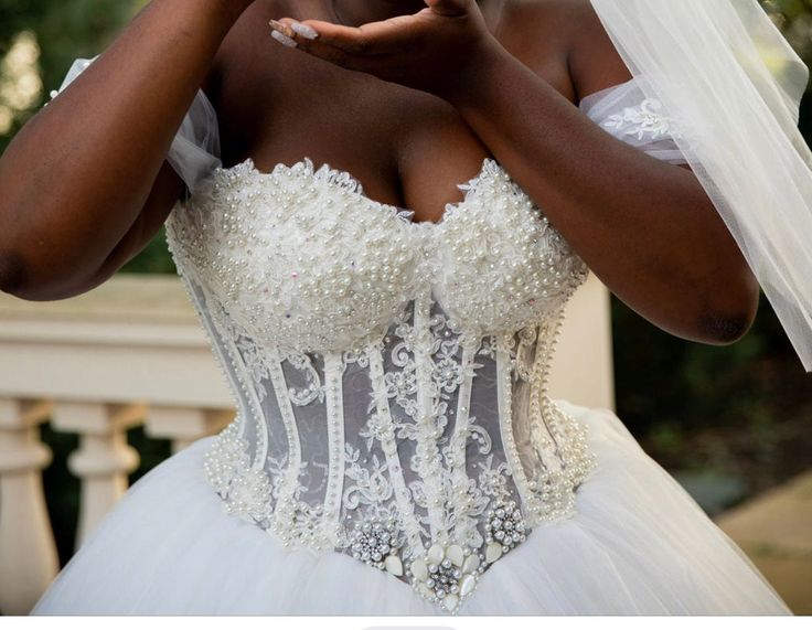 a woman in a wedding dress is holding her hands together