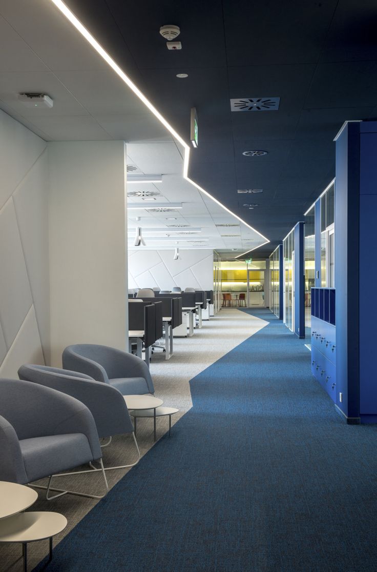 an empty room with chairs and tables in the center, along with blue carpeting