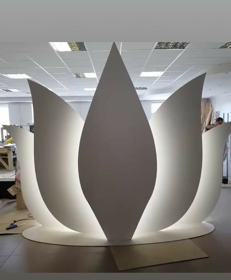 a large white sculpture sitting on top of a hard wood floor in an office building