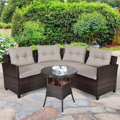 an outdoor sectional sofa set with cushions on a stone patio in front of some bushes