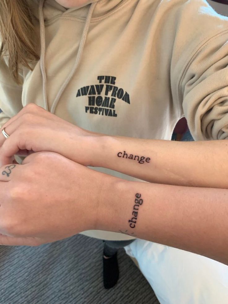 two people with matching tattoos on their arms, one has the word change written on it