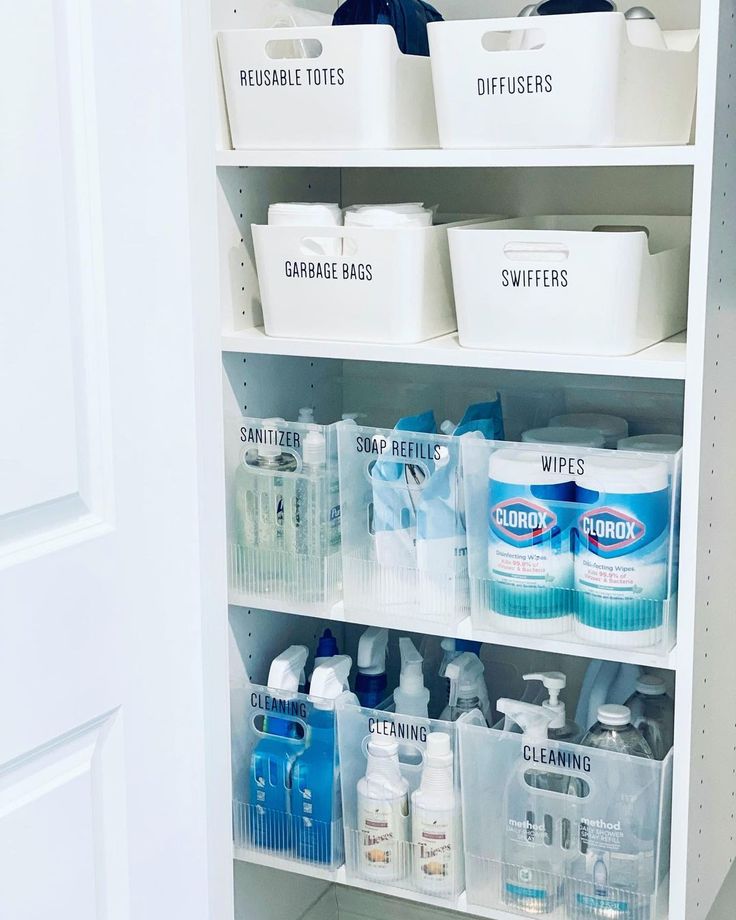 an organized pantry with white bins filled with cleaning products