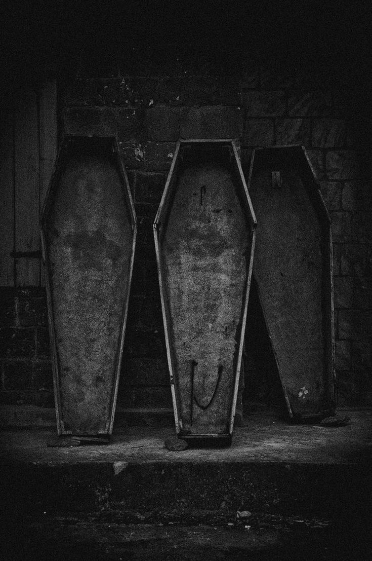 three empty bins sitting in front of a brick wall