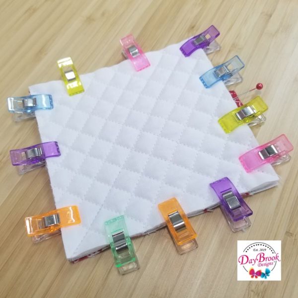 several colored clips are placed on top of a white piece of fabric