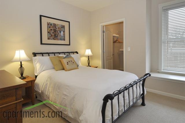 a bedroom with white bedding and two lamps on either side of the headboard