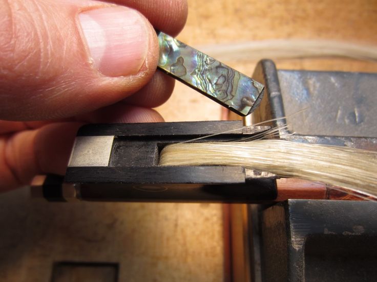 a person holding a piece of metal in their right hand and pulling it out of the box