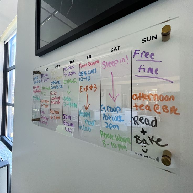 a white board with writing on it in front of a window next to a wall