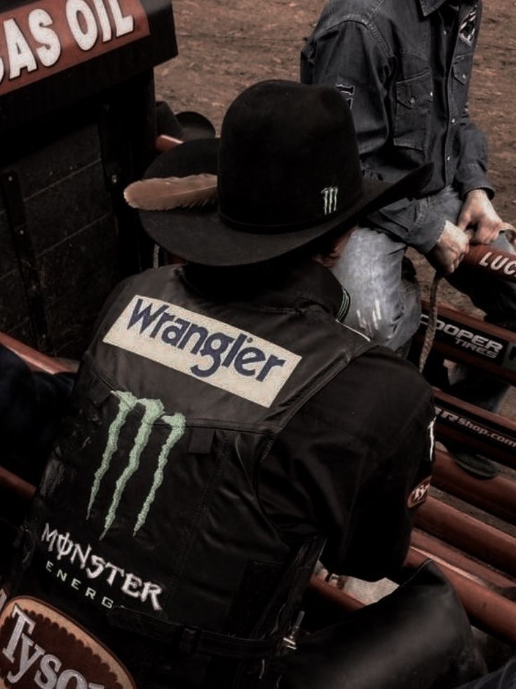 two men sitting in the back of a truck with their backs turned to one another