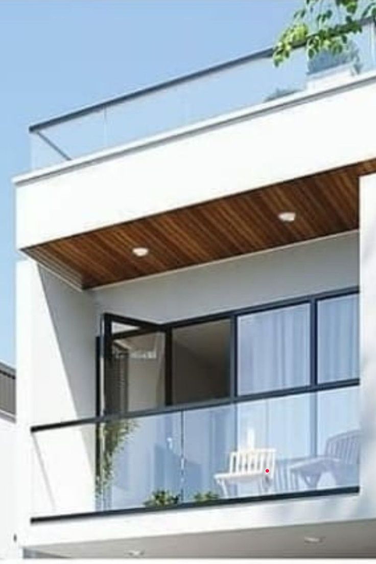 a white house with glass balconies on the balcony