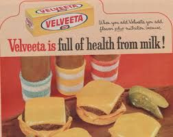 an advertisement for velveeta is shown with sandwiches and pickles on the table