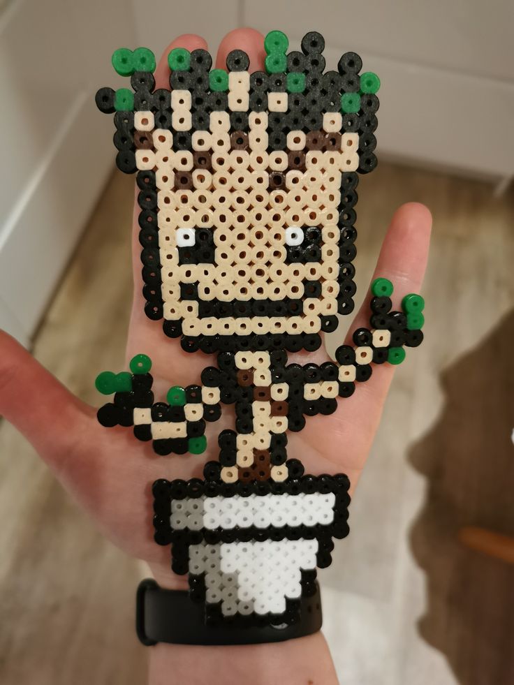 a person's hand holding a small beaded toy