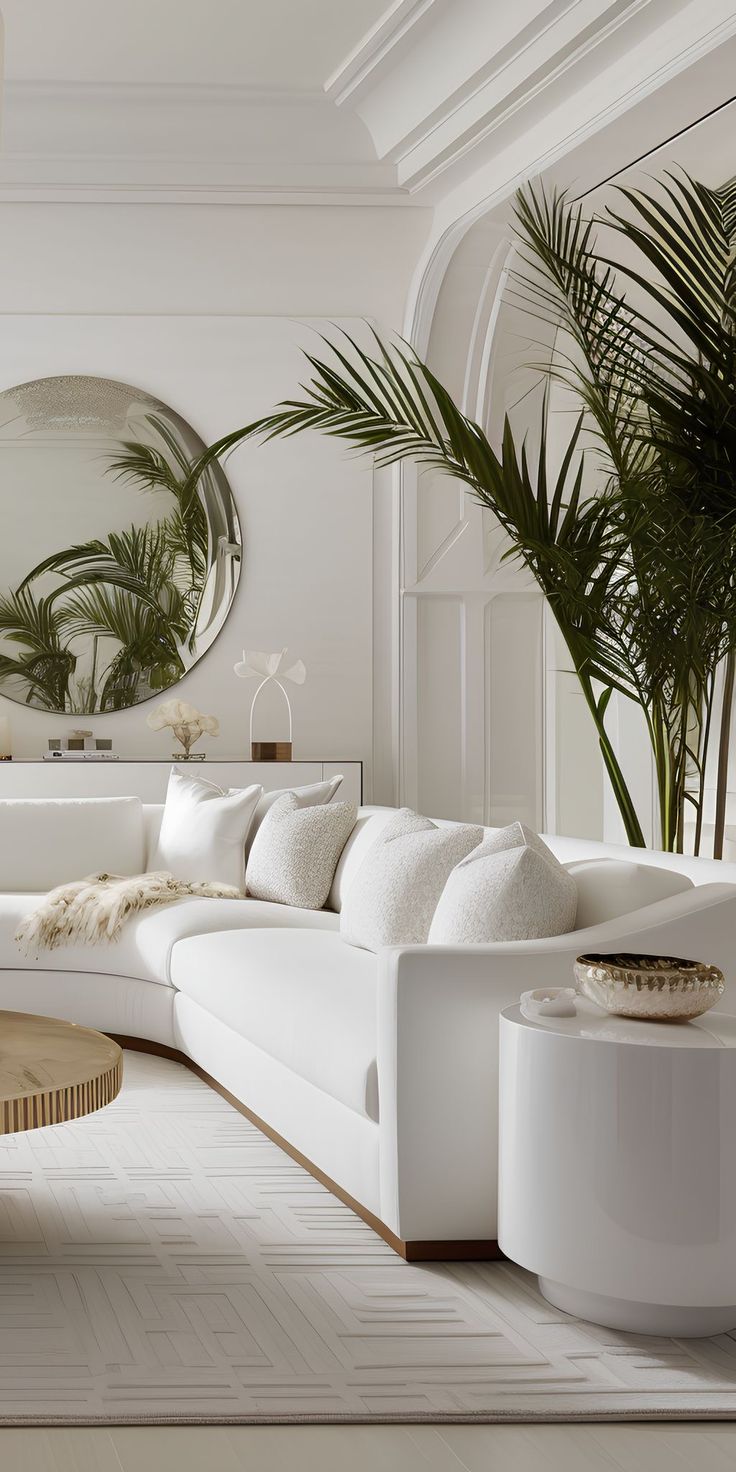 a living room with white furniture and plants