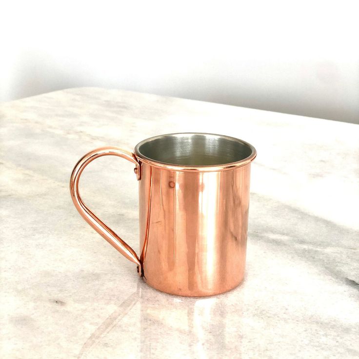 a shiny metal cup sitting on top of a white counter