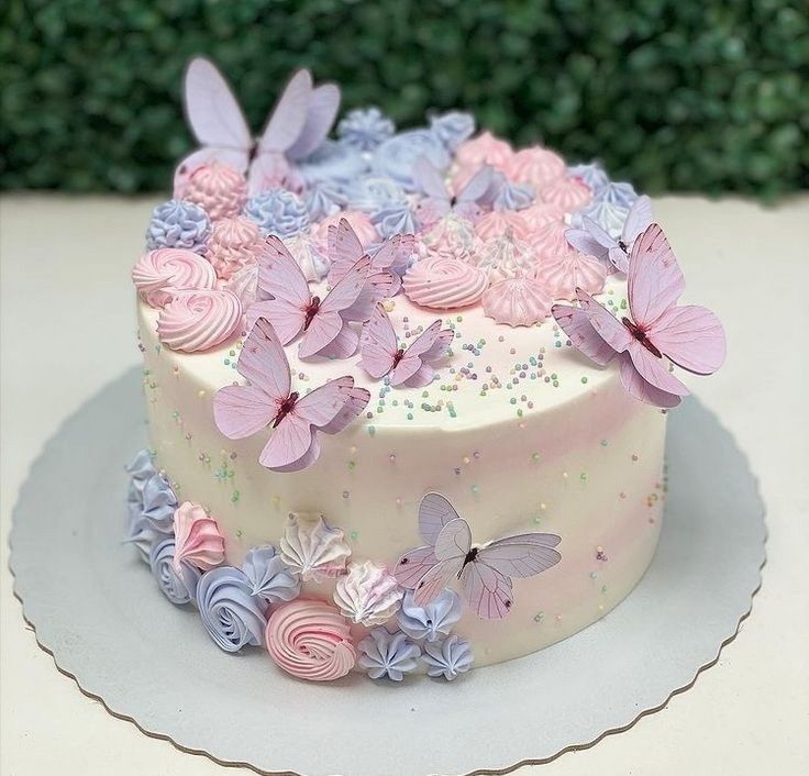 a white cake with pink and purple butterflies on it