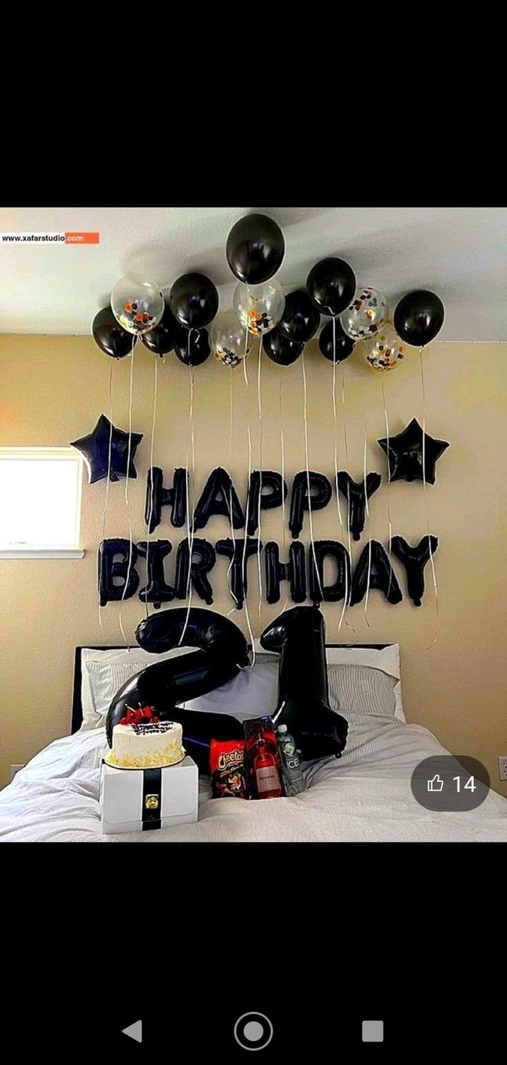 a birthday party with balloons and gifts on the bed in front of a happy birthday sign