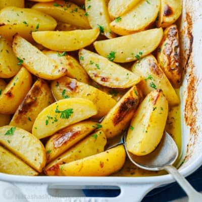 cooked potatoes in a casserole dish with a spoon