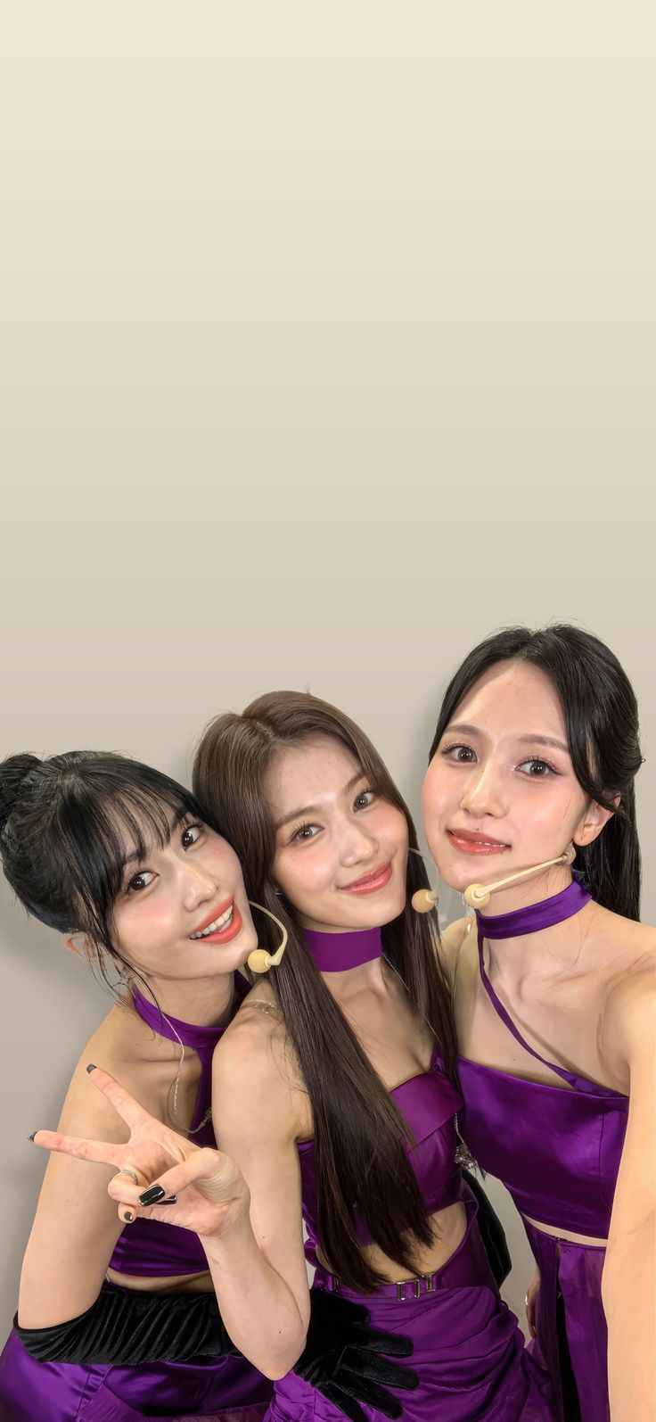 three young women in purple dresses posing for a photo with one pointing at the camera