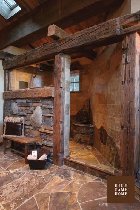 a stone fireplace in the corner of a room with wood beams and exposed ceilinging