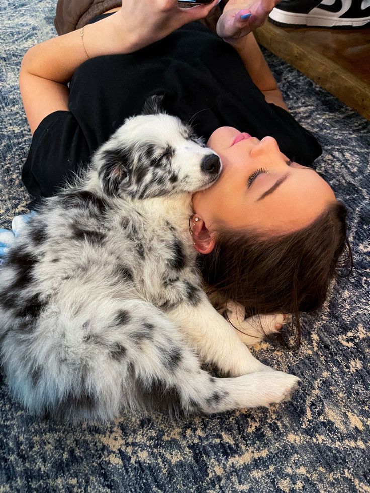 a woman laying on the floor with her dog