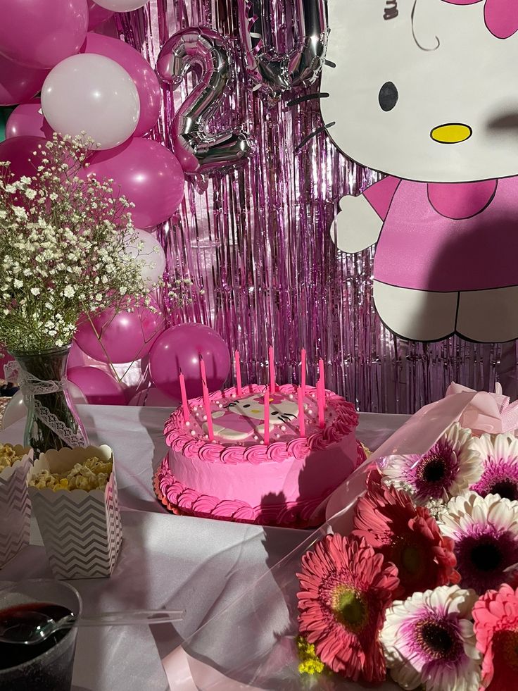 a hello kitty themed birthday party with pink and white balloons, cake, flowers, and streamers