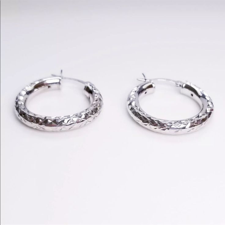 New 14k White Gold On 925 Sterling Silver Fancy Design Diamond-Cut Hoop Earrings Material: 14k White Gold Layer On Solid 925 Sterling Silver Stamped - 925 Stone Set : N/A Measurement : Approx. Width : 0 . 1 5 " Inches ( 3 . 8 Mm) Approx. Height : 1 . 0 1 " Inches ( 2 5 . 8 Mm) Approx. Weight: 3 Grams - 4 Grams Free Gift Box Or Gift Pouch Item # Acr09162018-Se-13 -Handcraft Artisan Jewelry -With Over 50,000+ Satisfying Customers Worldwide Promotional Calibrate Luxury Silver Huggie Earrings With Polished Finish, Luxury Round Sterling Silver Huggie Earrings, Luxury Silver Round Huggie Earrings, Hallmarked Sterling Silver White Gold Earrings, Hallmarked White Gold Sterling Silver Earrings, Luxury White Gold Hoop Earrings In Sterling Silver, White Gold Sterling Silver Hoop Earrings For Pierced Ears, Silver Huggie Fine Jewelry, Sterling Silver White Gold Hoop Earrings