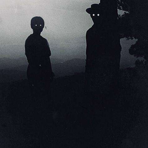 two people standing next to each other in front of a dark sky with the moon behind them