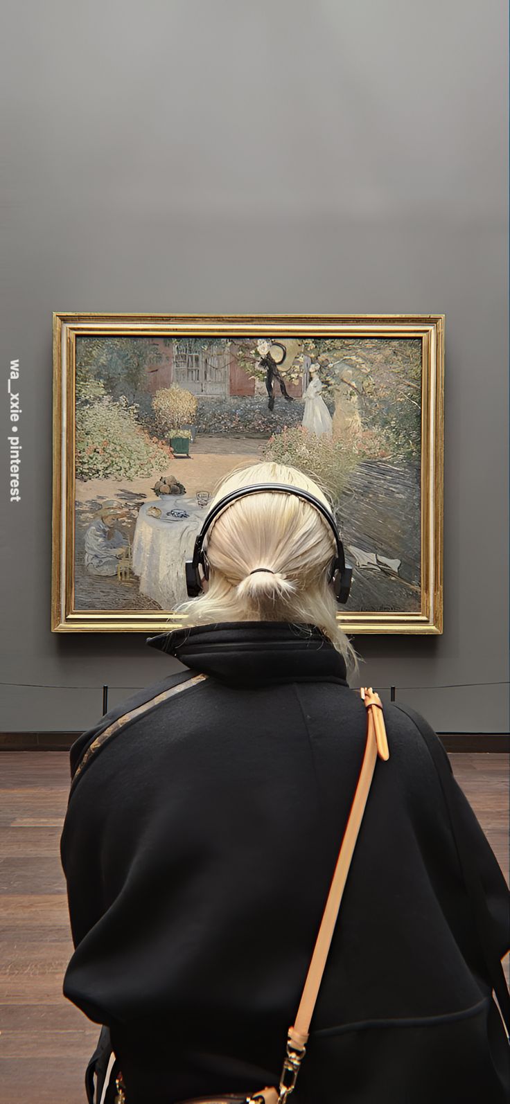 a woman looking at a painting on the wall