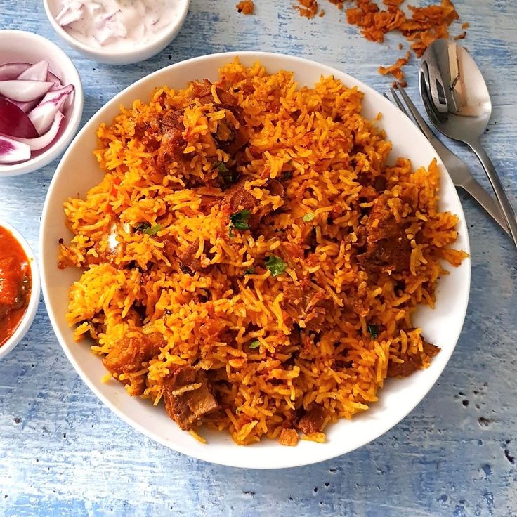 a white plate topped with lots of food next to two bowls filled with sauces