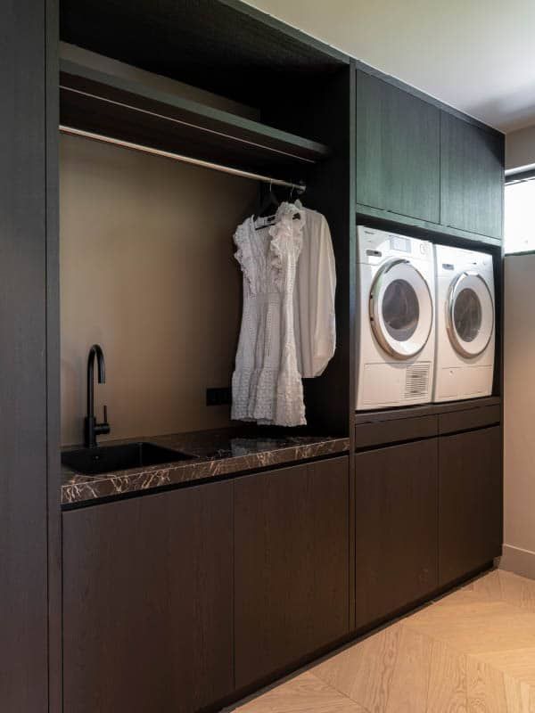 a washer and dryer sitting in a room next to each other on top of cabinets