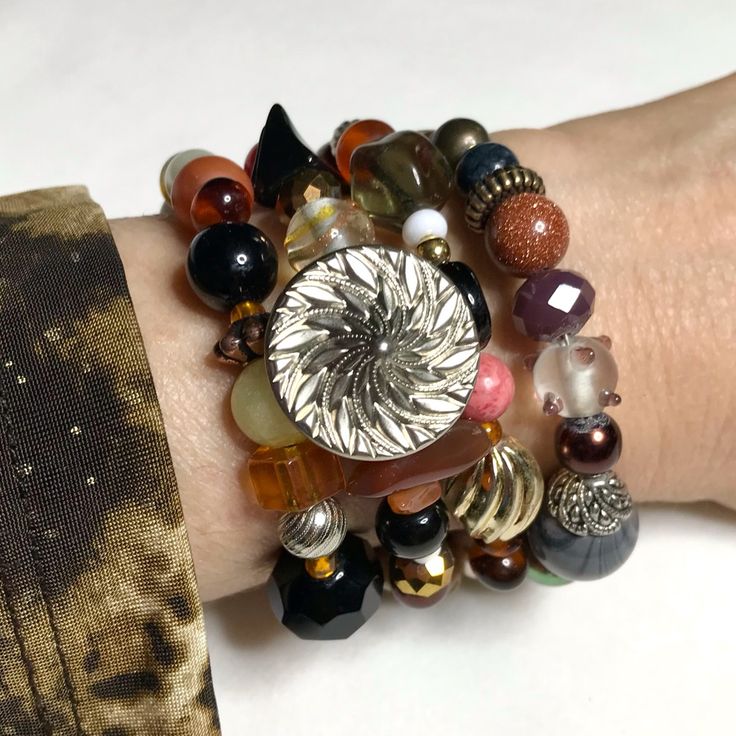 This Original Design Bracelet Was Created By Hand Using Vintage & Modern Elements Of Stone, Crystal, Stone, Faux Pearl, Shell And More In Tones Of Orange, Rust, Brown, Black, And White. Plain Pics Show The Flexible Continuous Revolutions Of Steel Wire. Note A: Silver Tone Metal Button, Balls Of Gold Stone & Yellow Jade (Pic1) Tibetan Agate Barrel, Picture Jasper Disc, Vintage Orange Oblong, Vintage Black/White Clay Pyramid, Sparkle Specialty Glass, Vintage Gold Tone Twist (Pic 3-5) Mixed Age Met Adjustable Silver Bracelets With Unique Variations, Silver Adjustable Bracelets With Unique Variations, Hand Wrapped Metal Bracelets, Silver Bangle Bracelet With Faceted Beads, Fusion Style Beaded Bracelets For Jewelry Making, Silver Stretch Bangle Bracelet With Faceted Beads, Hand Wrapped Metal Round Bracelets, Silver Beaded Bracelets With Unique Variations, Adjustable Sterling Silver Beaded Fusion Bracelets