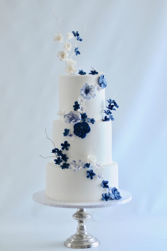 a wedding cake with blue and white flowers on it