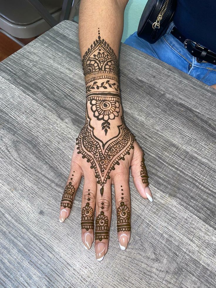 a woman's hand with henna tattoos on it