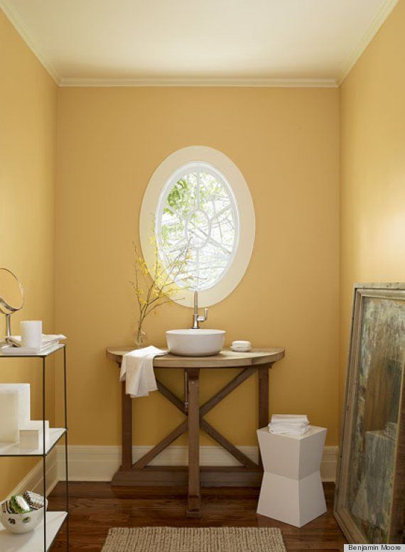 a bathroom with a round window and wooden floors