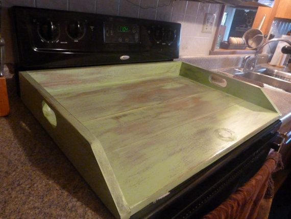 a green counter top in a kitchen next to a black stove and sink with a faucet