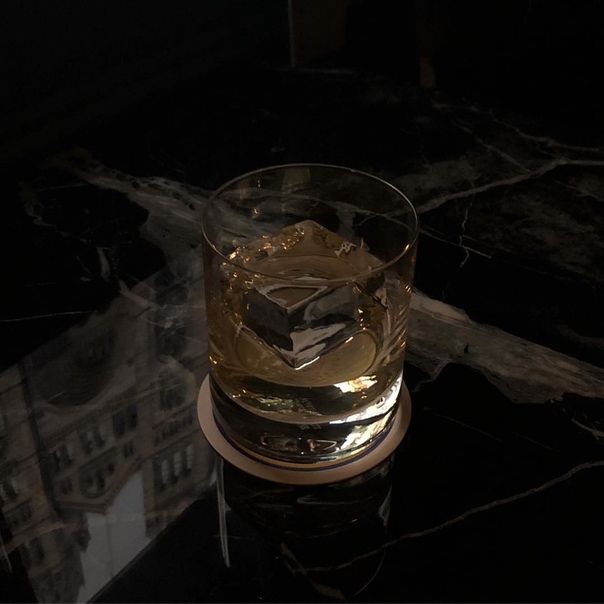 a glass filled with liquid sitting on top of a table next to a black counter