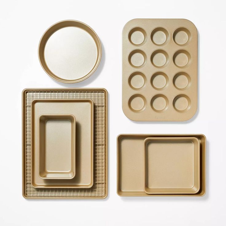 an assortment of baking supplies on a white surface with one empty tray and two uncooked plates