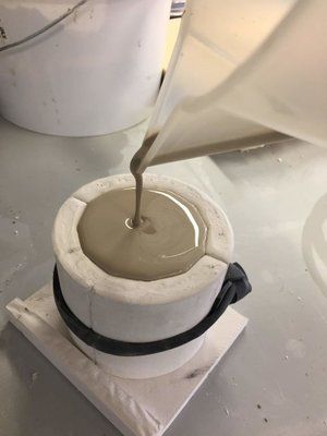 a person pouring something into a bowl on top of a table