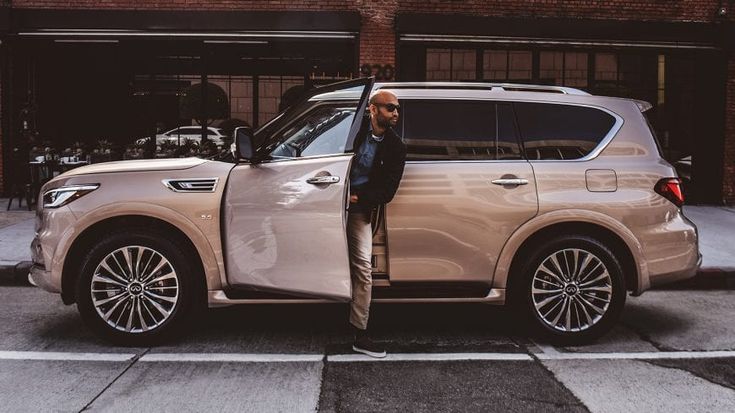 a man standing in front of a white suv