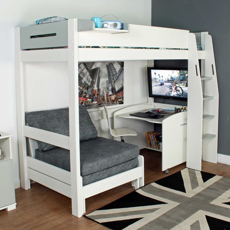 a white bunk bed sitting next to a desk with a tv on top of it