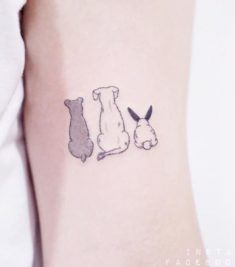 a small dog and cat tattoo on the left side of the arm, which has two smaller dogs sitting next to each other