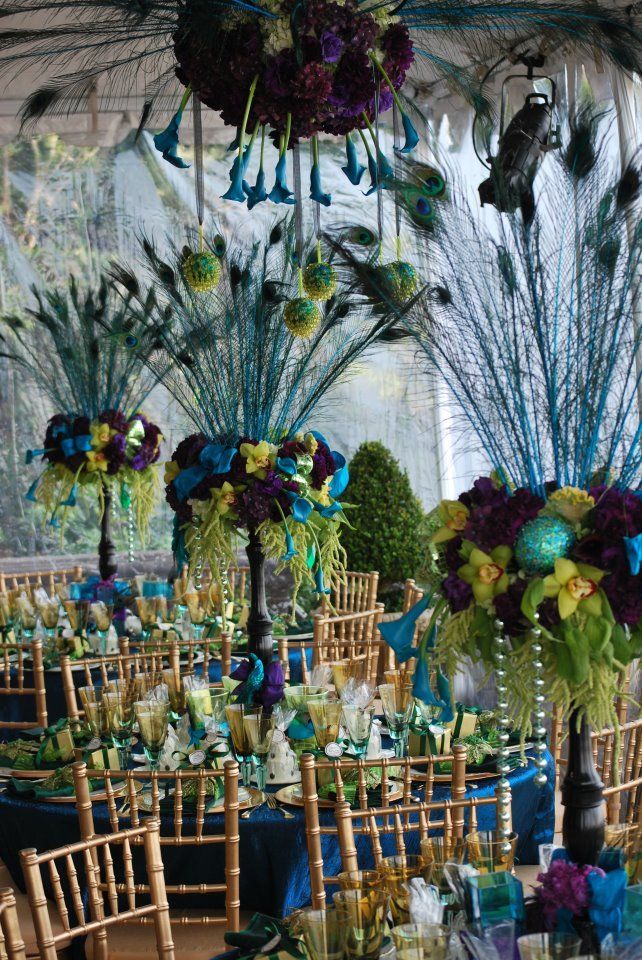 tables and chairs are set up with peacock feathers on them for an elegant wedding reception