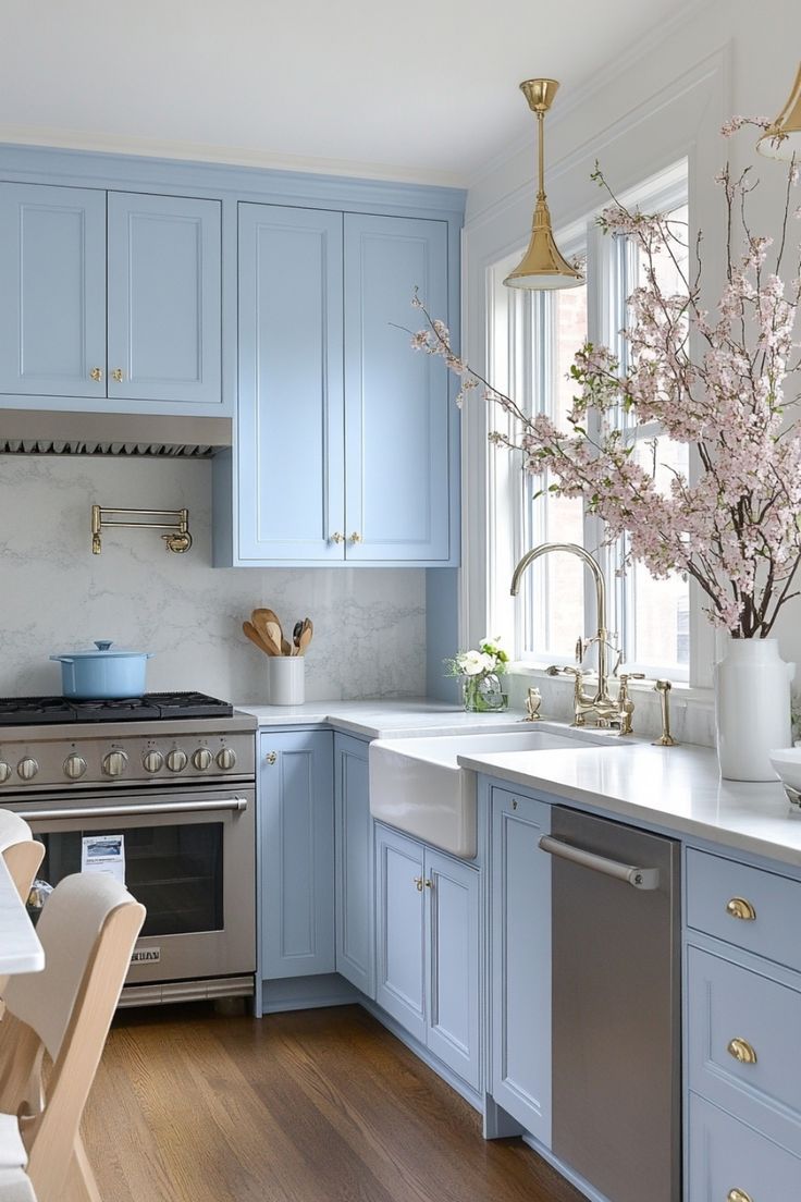 a kitchen with blue cabinets and white counter tops is pictured in this image, there are flowers on the island